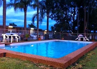 Mayfield Motel’s pool at dusk with the lit room row behind it.