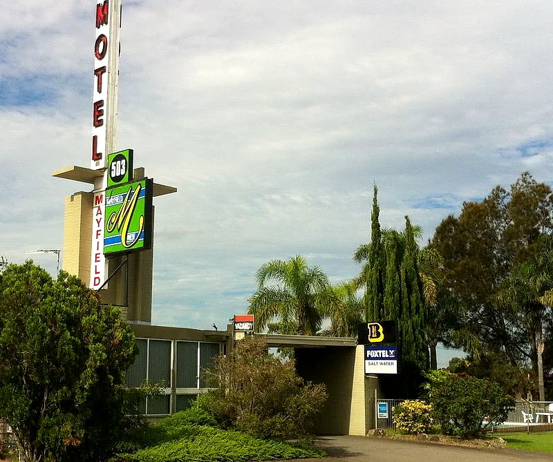 Mayfield Motel’s pylon sign and mid-century entrance canopy in daylight.